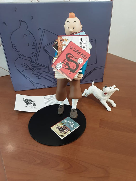 Tintin tenant ses albums, Milou à ses côtés