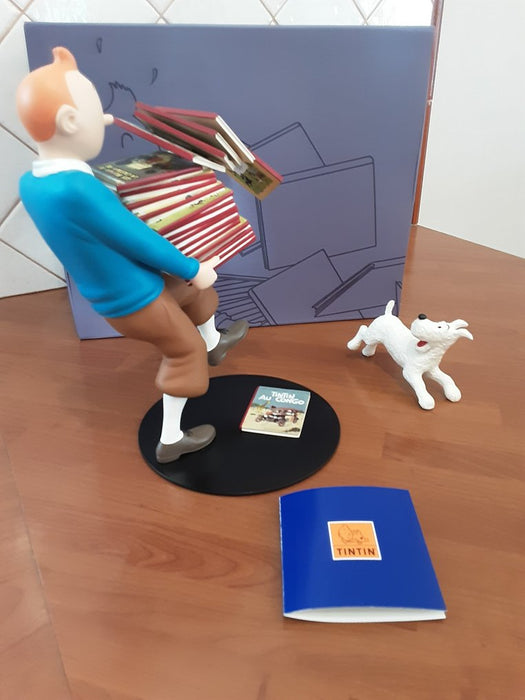 Tintin tenant ses albums, Milou à ses côtés