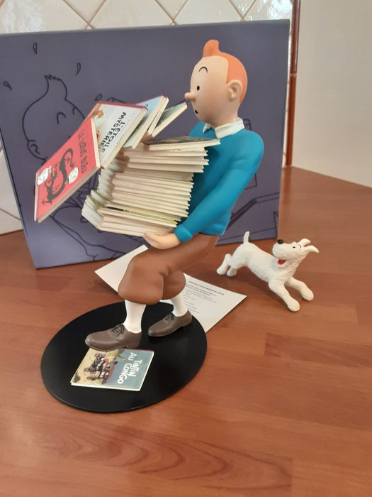 Tintin tenant ses albums, Milou à ses côtés