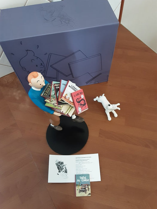 Tintin tenant ses albums, Milou à ses côtés
